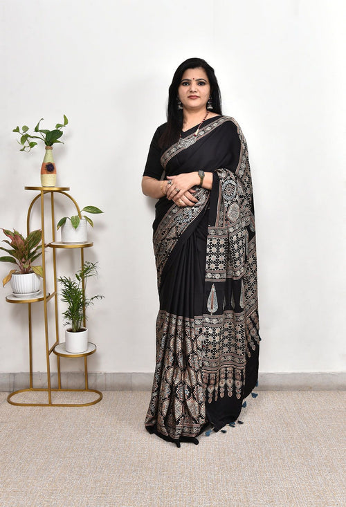 Woman wearing royal black antique printed modal silk saree with intricate heritage motifs, handcrafted ethnic border, designer pallu and tassels, elegant Indian saree for festivals, parties, office wear, weddings, cultural events and traditional ethnic fashion.